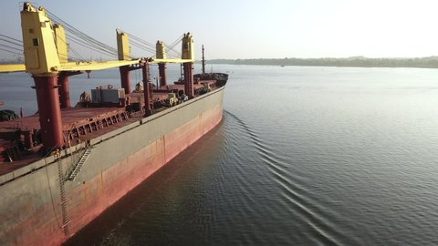 Cargo boat loaded with dry freight bulk commodities. Bulker sailing river, dispatch seaport to transfer coars grain, ore, coal. Logistic ship at daytime, close view container bulk carrier with wheat