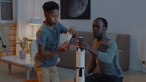 African American father and son playing together, building moon landing mission rocket together. Stay home, quarantine, science. ARRI Alexa Mini