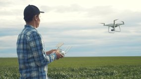 smart farming tech agriculture farming. man farmer engineer studies a wheat crop in a green field using a technology quadcopter. male red worker neck works in a green lifestyle field in a field of - Powered by Shutterstock - Get 15% off with code: PIKWIZARD15