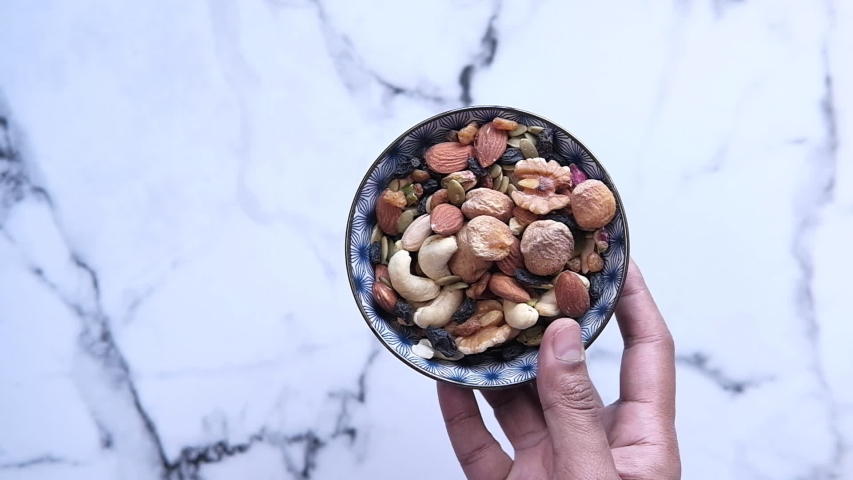 Top view of a bowl of mixed nut in tiles background 
