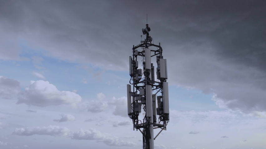 Aerial view of the telecommunication tower transmitting digits signals of cellular mobile 5g 4g 3g. Simulated radio waves Royalty-Free Stock Footage #1052809670