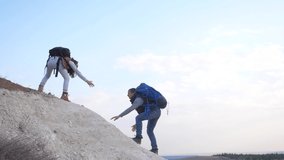 couple teamwork help silhouette business travel slow motion video concept lifestyle . man and girl holds out a helping hand mutual assistance camping adventure a pair of hikers climb a mountain holds