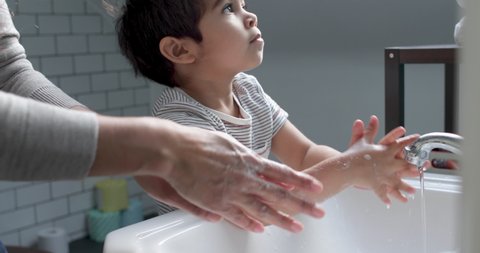 CU Mother assisting son (2-3) washing hands in bathroom / London, UK