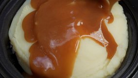 This POV closeup video shows yummy brown gravy being poured slowly over a bowl of fresh mashed potatoes. - Powered by Shutterstock - Get 15% off with code: PIKWIZARD15