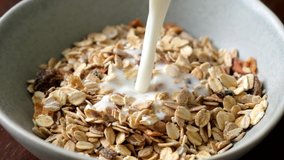 Slow motion milk pouring in bowl of muesli breakfast cereals. Healthy food - Powered by Shutterstock - Get 15% off with code: PIKWIZARD15