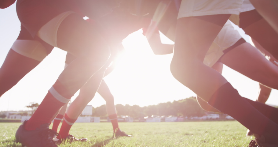 Side view close up of two teenage multi-ethnic male teams of rugby players wearing their team strips, in action forming a scrum during a rugby match on a playing field in slow motion Royalty-Free Stock Footage #1052829236