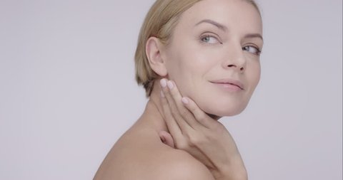 Close up of Beautiful healthy woman touching smooth skin on face in slow motion for beauty skincare concept on a grey background Shot in 6K on RED EPIC DRAGON