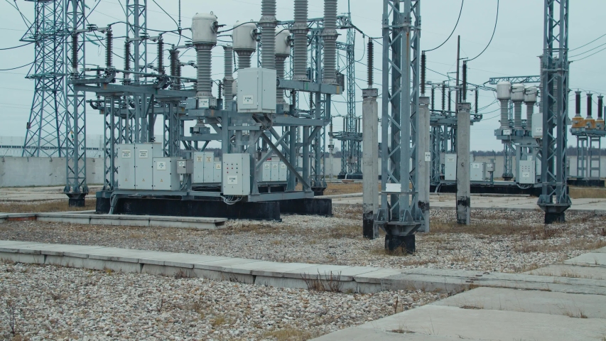 High voltage substation 110 kV with tall pylons and hog voltage distribution cables. Transformation station and electric power  Royalty-Free Stock Footage #1052835413
