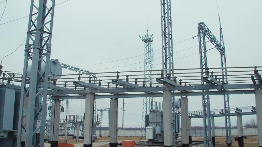 High voltage substation 110 kV with tall pylons and hog voltage distribution cables. Transformation station and electric power  Royalty-Free Stock Footage #1052835419