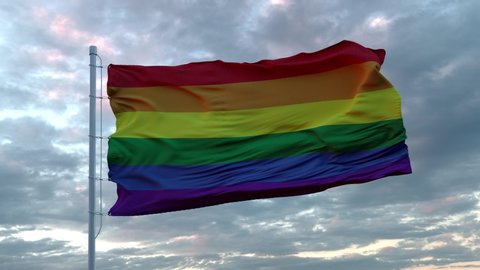 Realistic flag of LGBT pride waving in the wind against deep Dramatic Sky. 4K UHD 60 FPS Slow-Motion