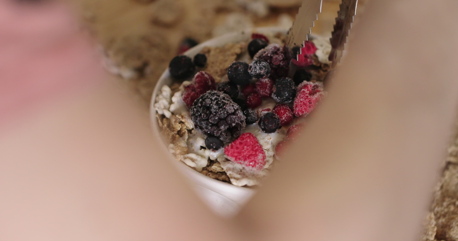 granola cereal and milk into the bowl for breakfast, cereals and muesli with dried fruit for breakfast