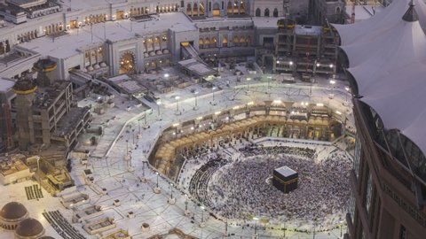 Time lapse sunrise of Muslim pilgrims circling around the holy Kaaba at dawn and praying inside al Masjid al Haram in Mecca, Saudi Arabia. Zoom out motion. Prores Full HD