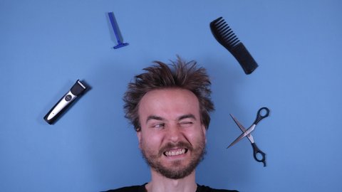 Stop motion animation funny face of bearded disheveled shaggy man and barber grooming hairdresser tools accessories on blue background. Barber shop, hairdresser, cutting hair at home.
