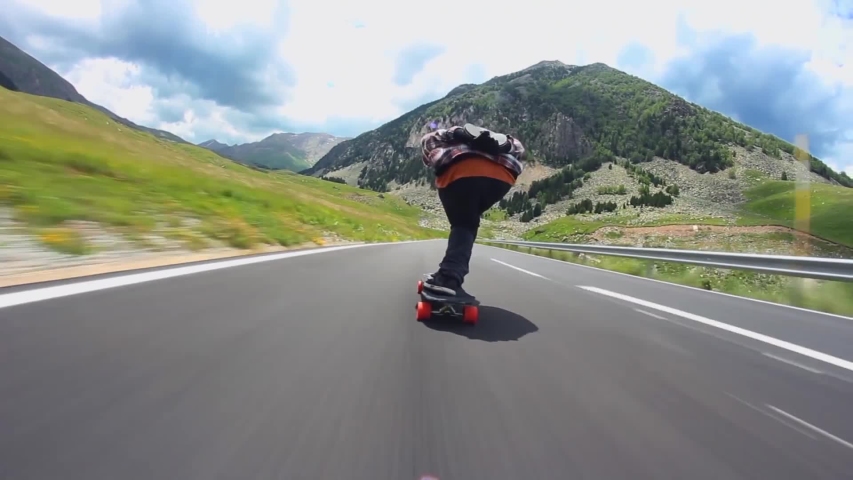 Downhill road in mountain landscape professional skater skating longboard fast in first person pov | Shutterstock HD Video #1052853230
