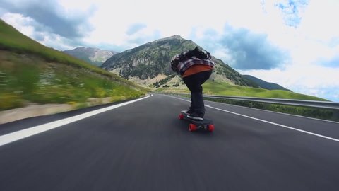 pov longboard skater downhill by mountain road