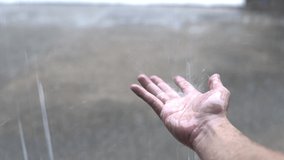 Human hand catching rain drops during rainy season.