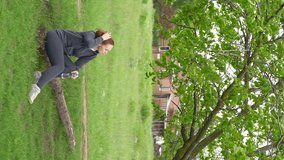vertical videos. Woman sitting on the lawn after Jogging and exercising, resting and drinking water. water balance during exercise.