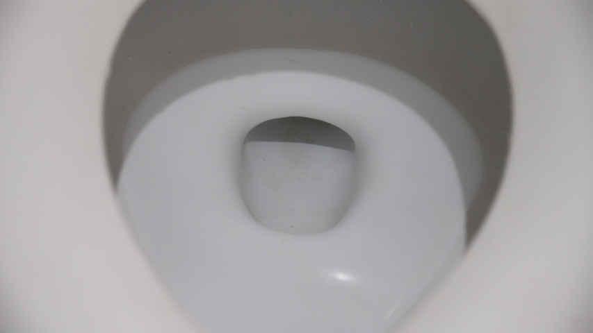 The flushing of toilet tissue paper down a bathroom toilet. Close up of a water with paper flushing down into the toilet bowl in bathroom. Royalty-Free Stock Footage #1052859752