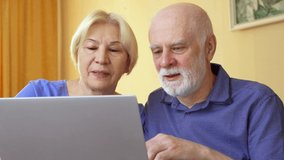 Senior couple working from remote home office on laptop. Retired family staying home and using computer to have video chat with their children. Active modern lifestyle on retirement