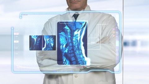A modern Doctor examines a Virtual HUD / UI board with MRI medical hi-tech data scans for diagnosis, in a contemporary clinic center. Magnetic Resonance Imaging display: Cervical Spine (skeletal neck)