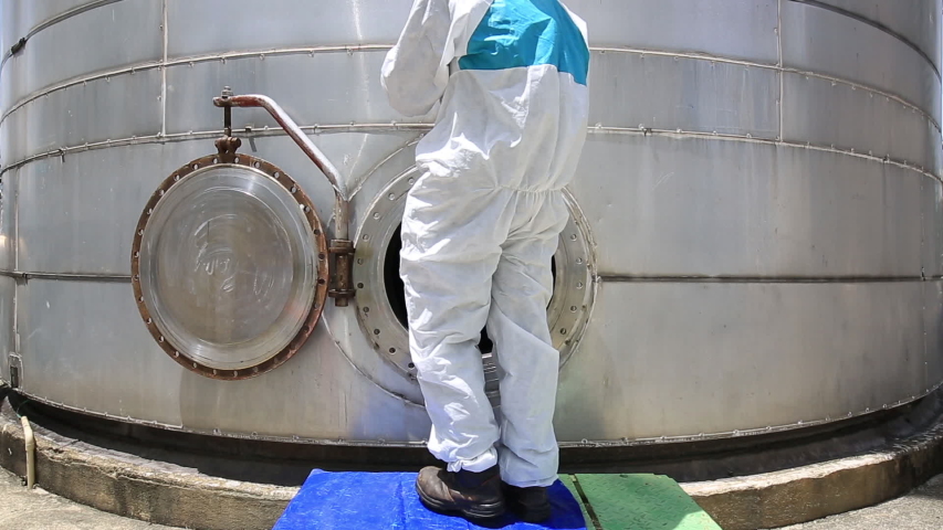 Male worker into  manhole fuel tank oil chemical protective clothing area confined space dangerous