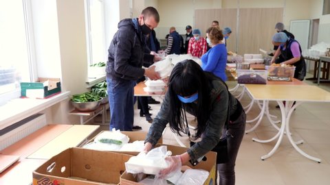 CHERKASY, UKRAINE, MAY 18, 2020: Volunteers are packing Lunchboxes, free meals to be delivered to poor and homeless people during lock down of covid19. Charity project, donating aid, food delivery
