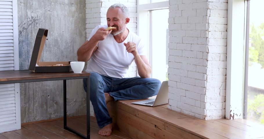 An adult man works at home on self-isolation, makes online orders, uses a coputer