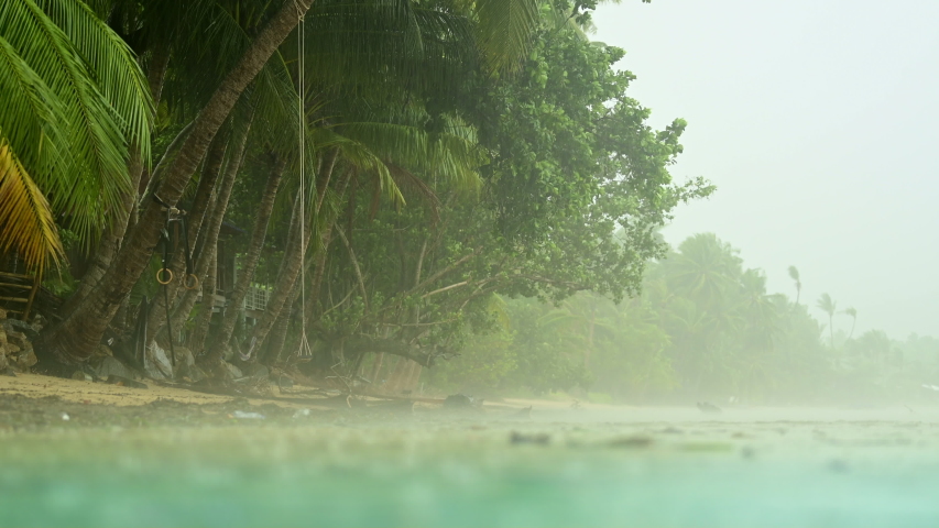 Torrential heavy rain on a tropical island beach. Raining season in tropics.