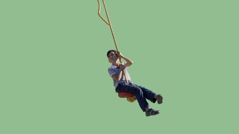 A small boy swings on a rope. Green screen video with transparent background