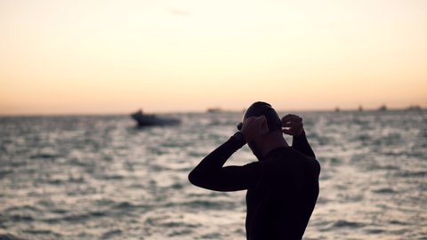Professional Triathlete Prepare To Swimming Workout On Sea. Professional Swimmer Wearing Cup And Goggles. Triathlete Sport Triathlon Swim. Swimmer Silhouette In Ocean Sport Recreation Competition.