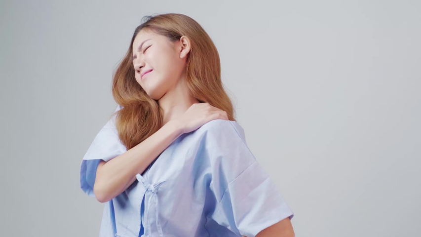 Exhausted Asia office worker rubs her shoulder due to the back and shoulder aches shows pain expression face, concept working exhausted, office syndrome, tiring work hour, rehabilitation treatment.