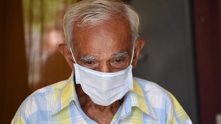 Old Senior Indian man wearing medical mask staring at the camera during the Coronavirus pandemic Royalty-Free Stock Footage #1052887676