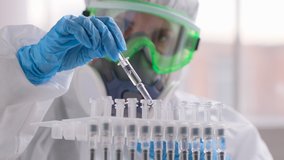 vaccine vaccination treatment Covid-19 Coronavirus COVID-19 flu virus. Doctor microbiologist virologist researcher scientist in laboratory in PPE, blue gloves analyzing ampoule syringe injection. 4 K - Powered by Shutterstock - Get 15% off with code: PIKWIZARD15