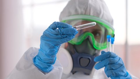 vaccine, treatment Covid-19 Coronavirus COVID-19 virus. Doctor microbiologist virologist researcher scientist in laboratory in PPE personal protective analyzing lab test tube in hand blue gloves, 4 K Stock-video