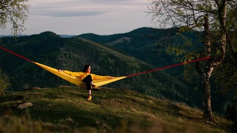 Woman relaxing on hammock and enjoys the scenery in the mountains