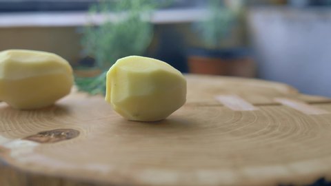 a man cuts the potato on the cutting Board sharp knife cut into slices