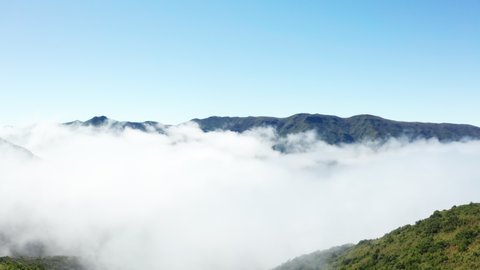 Madeira, Portuguese island inland mountain range over the clouds flying drone aerial 4K footage.