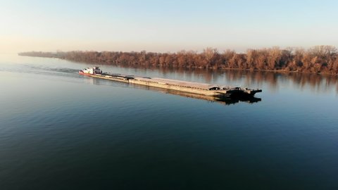 BELGRADE, SERBIA - CIRCA 2020: Aerial drone video of tugboat pushing barge on Danube river