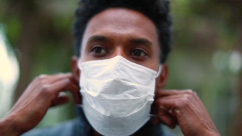 African man removing covid-19 mask, end of pandemic. Black person removes disease mask
