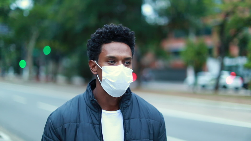 Black man walking city sidewalk wearing surgical mask for outbreak prevention, african person walking in urban environment Royalty-Free Stock Footage #1052899799