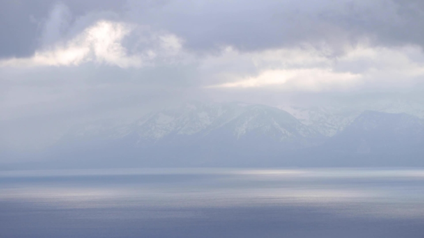 Beautiful shot of clouds rolling over Lake Tahoe with snow covered peaks in the background. 