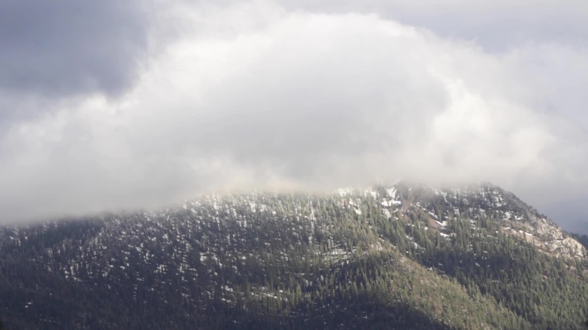 Clouds rolling over a mountain peak above Lake Tahoe. 