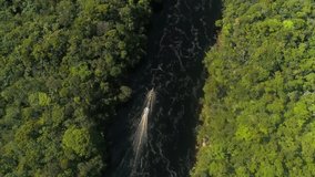 Aerial view of the beautiful Carrao River in Canaima National Park. In the water sails a board with tourists. Lovely Amazon rainforest