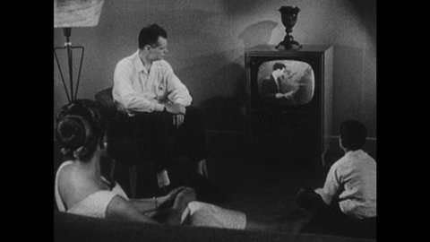 1950s: Family watches television. Meteorologist speaks.
