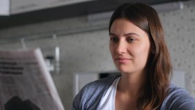 Newspaper News. World pandemic. Source of news. Read newspaper. Attractive female reads a fresh news newspaper while sitting at home in the kitchen. Close-up - Powered by Shutterstock - Get 15% off with code: PIKWIZARD15