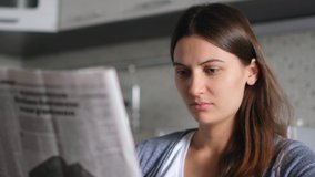 Newspaper News. World pandemic. Source of news. Read newspaper. Beautiful Woman reads a fresh news newspaper while sitting at home in the kitchen. Close-up - Powered by Shutterstock - Get 15% off with code: PIKWIZARD15