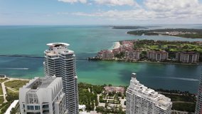 Lateral aerial video Miami Beach view of Fisher Island and inlet to port