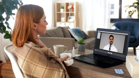 medicine, healthcare and technology concept - sick young woman having video call or online consultation with doctor on laptop computer at home