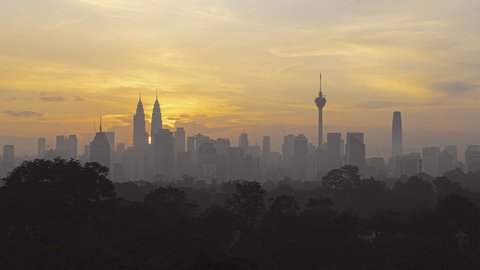 Time lapse: Silhouette of Kuala Lumpur city view during dawn overlooking the city skyline from afar with lushes green in the foreground. Federal Territory, Malaysia. Prores 4K