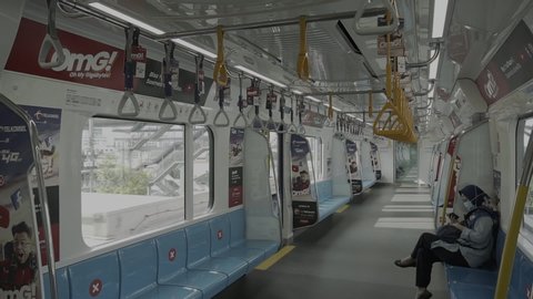Jakarta, Indonesia - April 24, 2020 : MRT situation with women and sign sitting information distance for one seat keep distance protect covid 19 pandemic